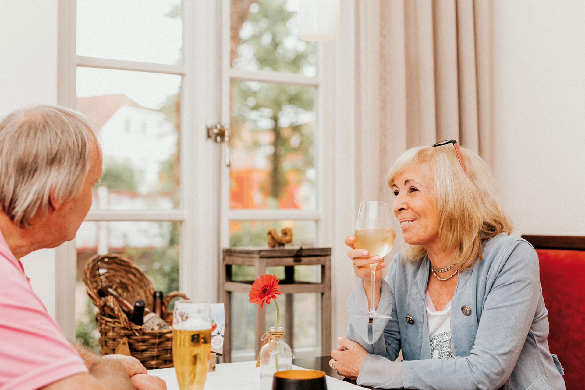 Frau trinkt Weißwein in Restaurant